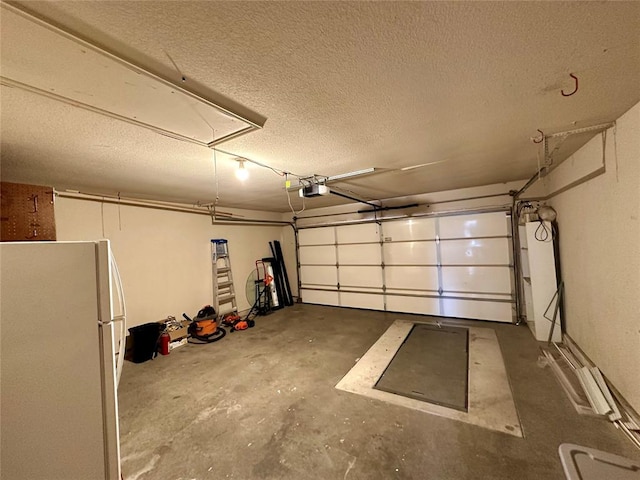 garage featuring white fridge and a garage door opener