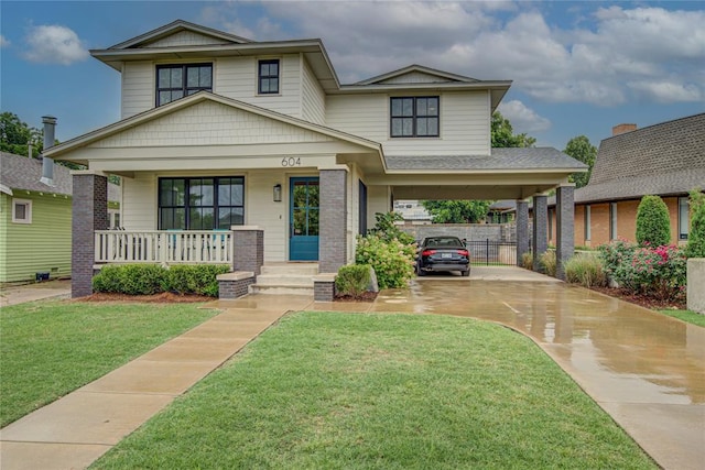 craftsman-style home with covered porch, a carport, and a front yard