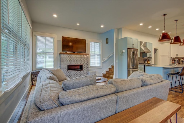 living room with hardwood / wood-style flooring, sink, and a fireplace