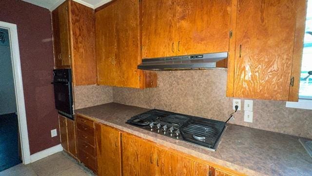 kitchen featuring stainless steel gas stovetop, oven, and tasteful backsplash