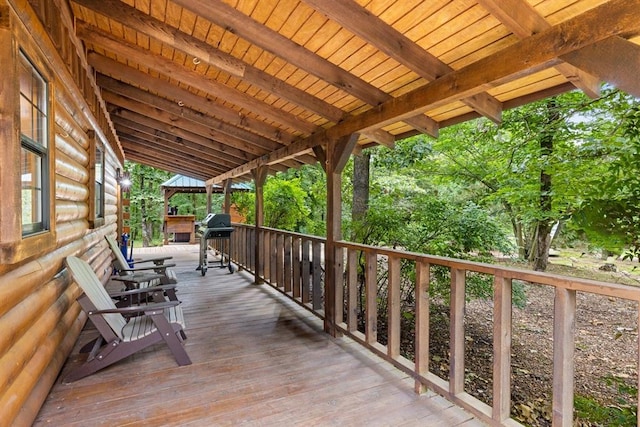 wooden deck with a grill and covered porch