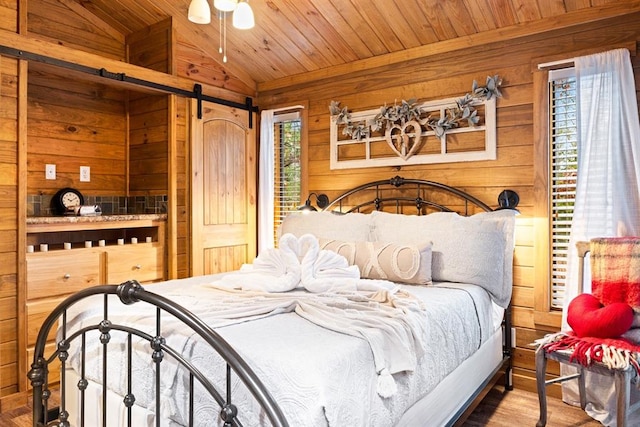 bedroom featuring multiple windows, hardwood / wood-style floors, wood ceiling, and lofted ceiling