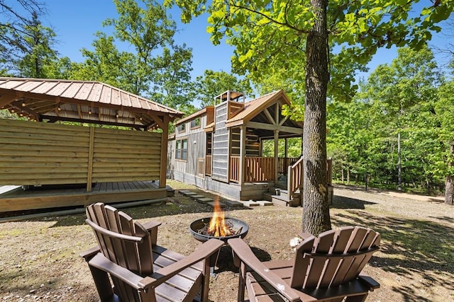 view of yard featuring a deck and an outdoor fire pit