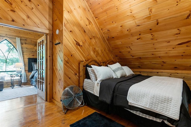 bedroom with wooden walls, high vaulted ceiling, wood-type flooring, and wooden ceiling