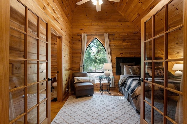 unfurnished bedroom featuring wooden ceiling, light hardwood / wood-style flooring, wooden walls, and ensuite bathroom