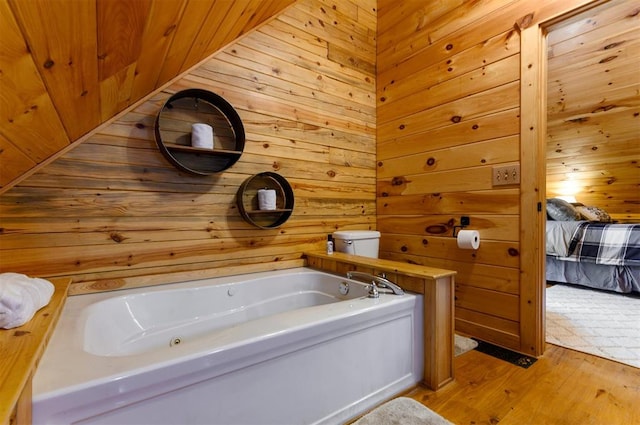 bathroom featuring wood-type flooring, a bathtub, and wood walls