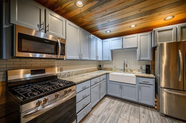 kitchen with light stone counters, sink, wooden ceiling, and appliances with stainless steel finishes