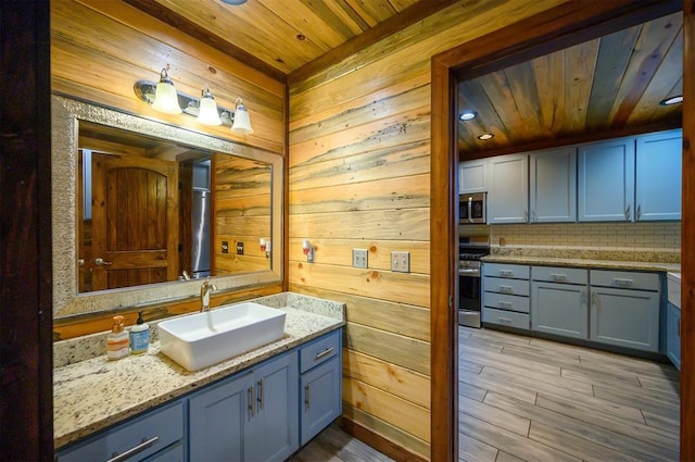 bathroom with wood walls, vanity, and wooden ceiling