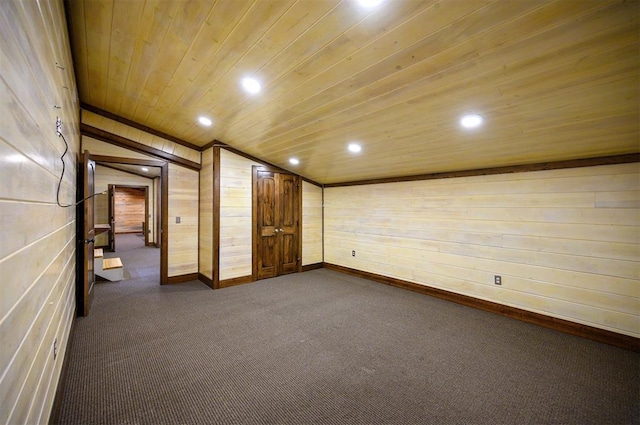 interior space featuring carpet floors, wood ceiling, wooden walls, and lofted ceiling