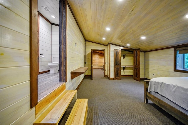 carpeted bedroom with lofted ceiling, wooden walls, ensuite bathroom, and wooden ceiling