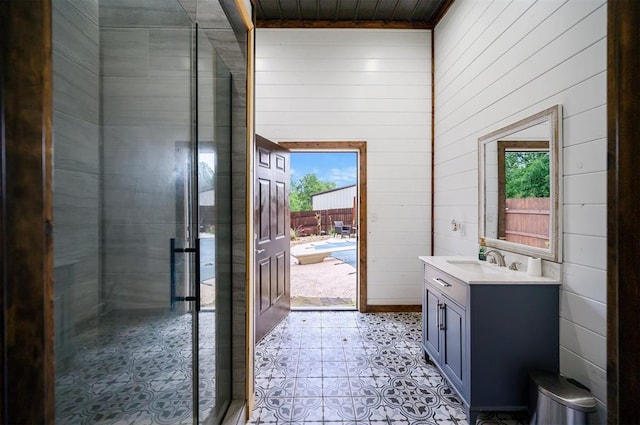 bathroom featuring a shower with door, vanity, wooden ceiling, and wooden walls