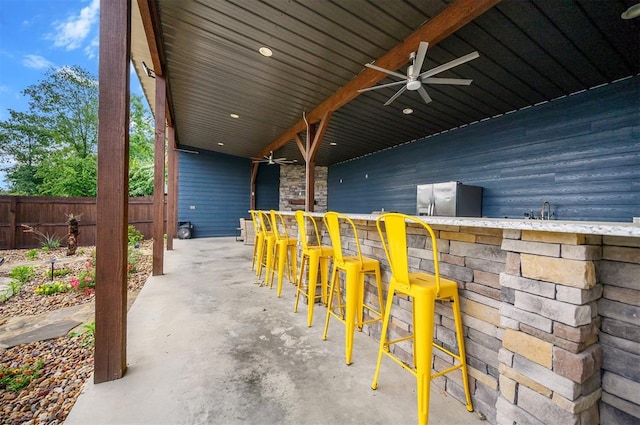 view of patio featuring a bar and ceiling fan