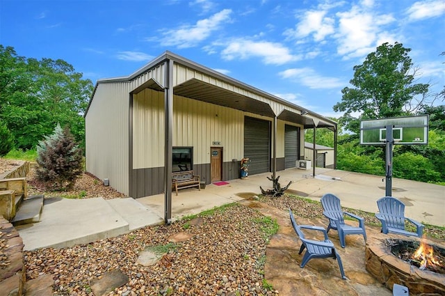 rear view of house featuring an outbuilding and a fire pit