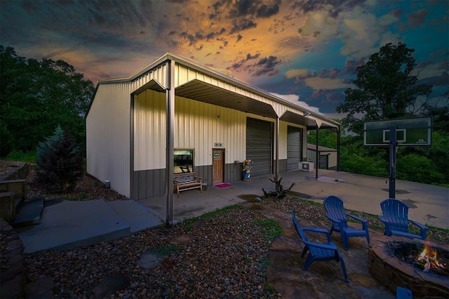 back house at dusk with a fire pit and a patio area