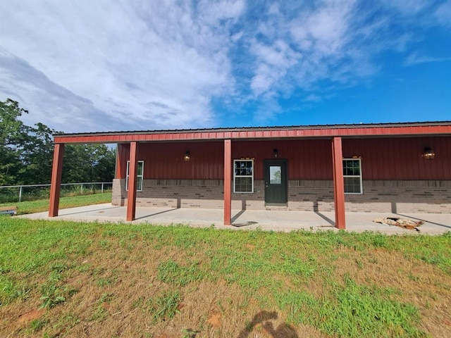 back of property featuring a patio area and a yard