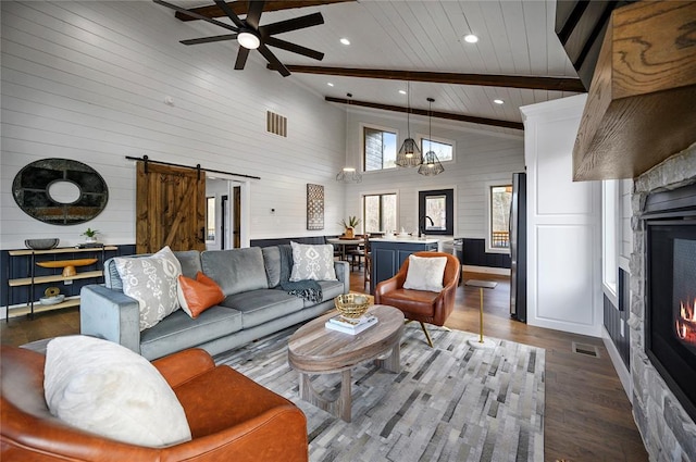 living room with sink, dark wood-type flooring, a barn door, high vaulted ceiling, and beam ceiling