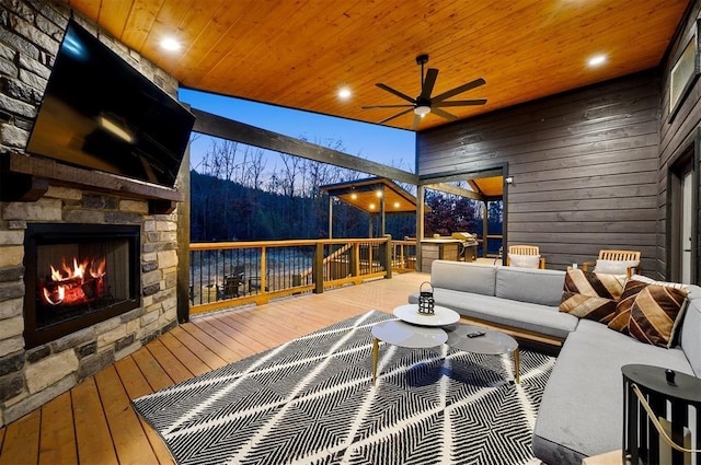 exterior space with ceiling fan and an outdoor living space with a fireplace