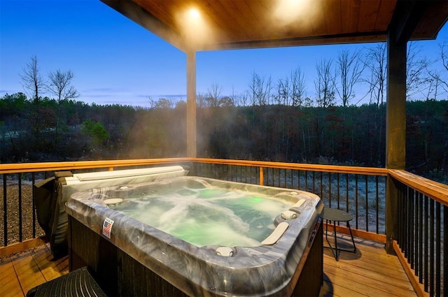 deck at dusk with a hot tub