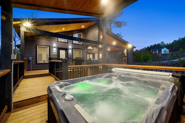 deck at dusk with a hot tub