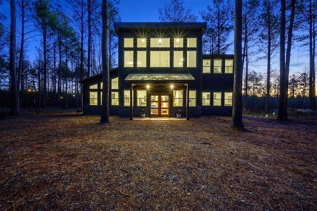 back house at dusk featuring french doors