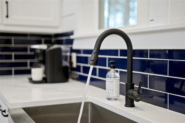 room details featuring sink and white cabinets