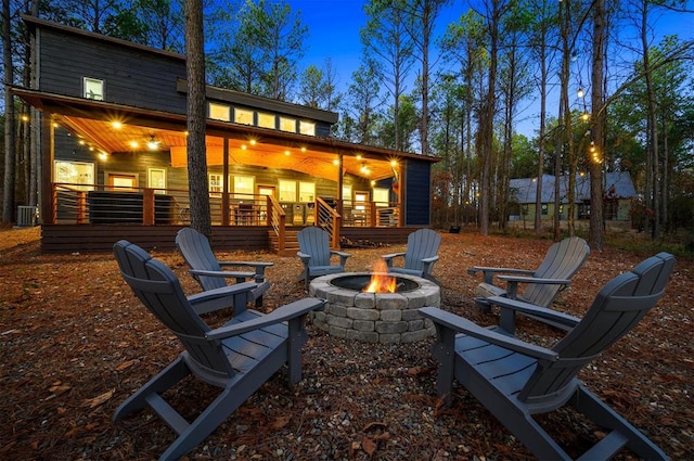 patio terrace at dusk with covered porch, a fire pit, and central air condition unit