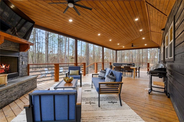 deck featuring an outdoor living space with a fireplace and ceiling fan