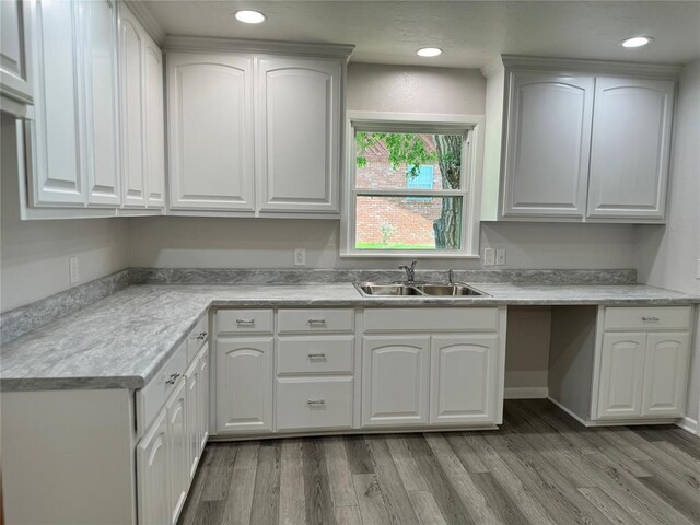 kitchen with sink, white cabinets, and light wood-type flooring