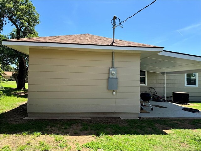 view of side of home featuring a lawn and central air condition unit