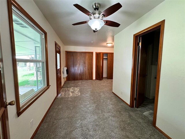 carpeted spare room with ceiling fan