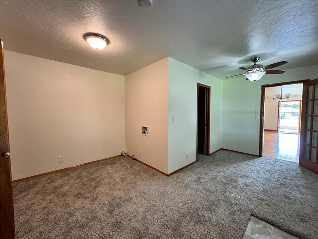 empty room featuring carpet flooring, a textured ceiling, and ceiling fan with notable chandelier