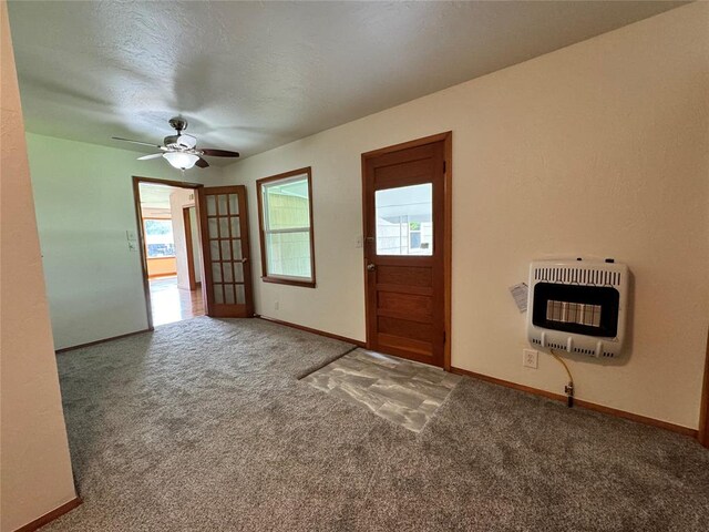 entryway with a textured ceiling, carpet floors, heating unit, and ceiling fan