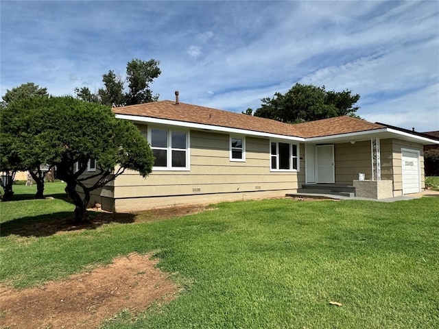 back of house featuring a garage and a lawn