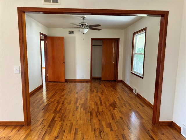 unfurnished bedroom with ceiling fan, a closet, and dark hardwood / wood-style floors