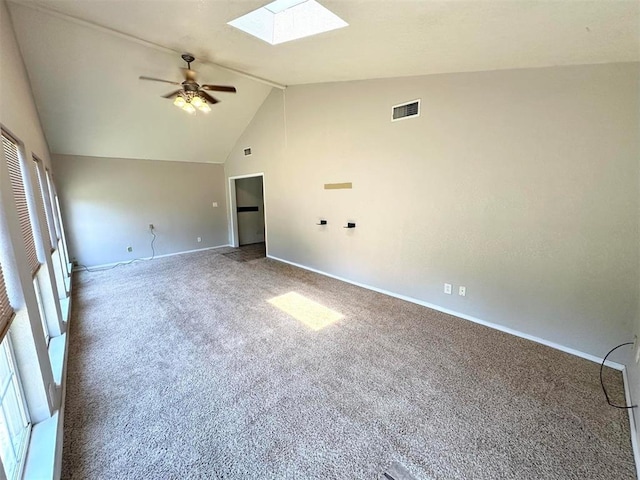 carpeted empty room with lofted ceiling with skylight and ceiling fan