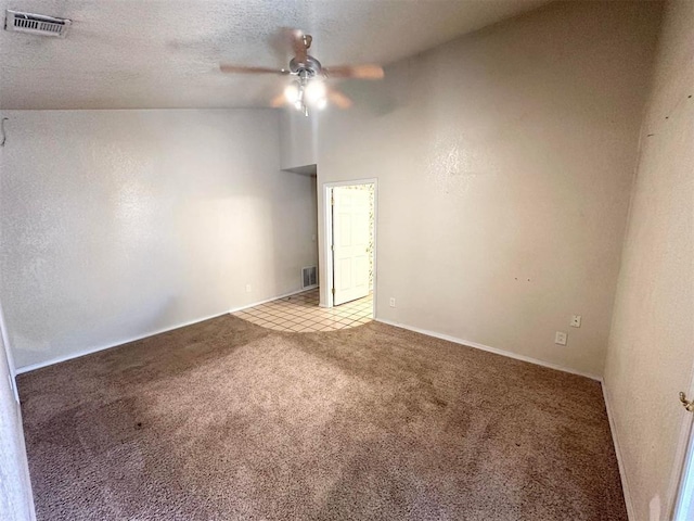 carpeted empty room with a textured ceiling, ceiling fan, and lofted ceiling