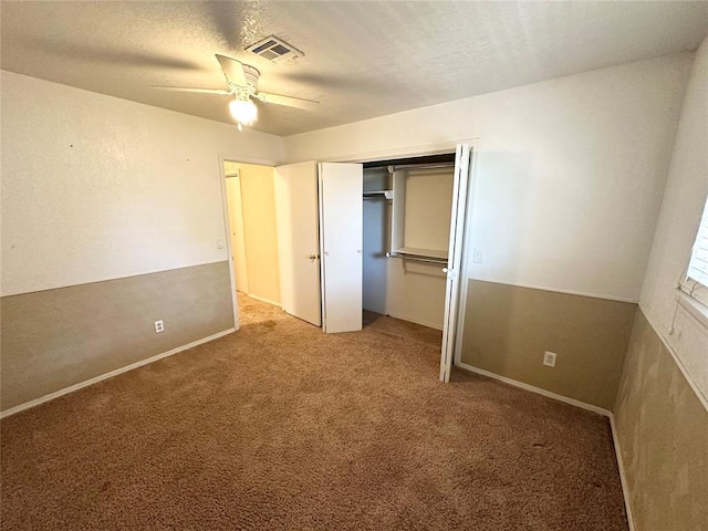 unfurnished bedroom featuring carpet flooring, ceiling fan, a textured ceiling, and a closet