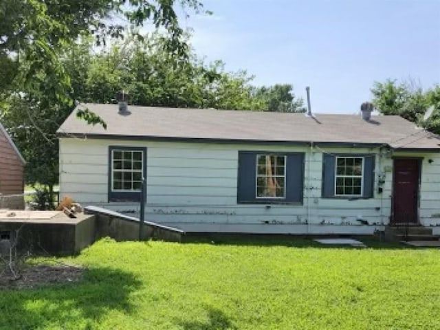 rear view of house featuring a yard