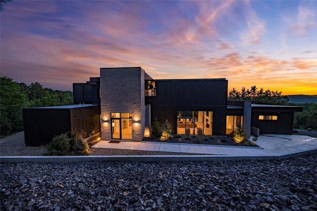 back house at dusk featuring central air condition unit