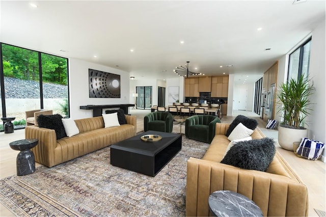 living room featuring expansive windows, a healthy amount of sunlight, and an inviting chandelier