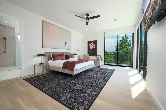 bedroom featuring access to outside, ceiling fan, connected bathroom, light hardwood / wood-style floors, and a wall of windows