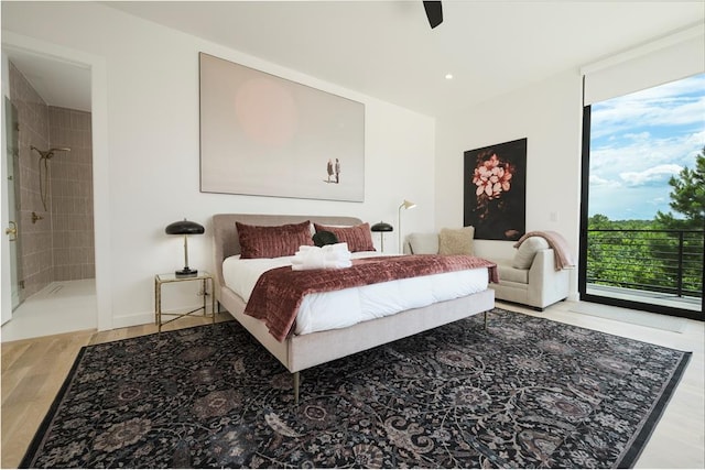 bedroom featuring connected bathroom, ceiling fan, multiple windows, and hardwood / wood-style flooring