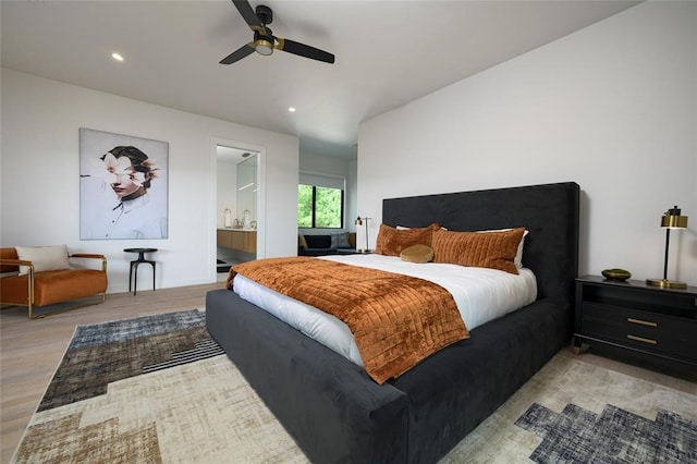 bedroom featuring ensuite bathroom, light hardwood / wood-style flooring, and ceiling fan