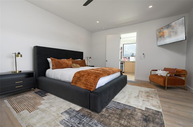 bedroom featuring connected bathroom, light hardwood / wood-style floors, and ceiling fan