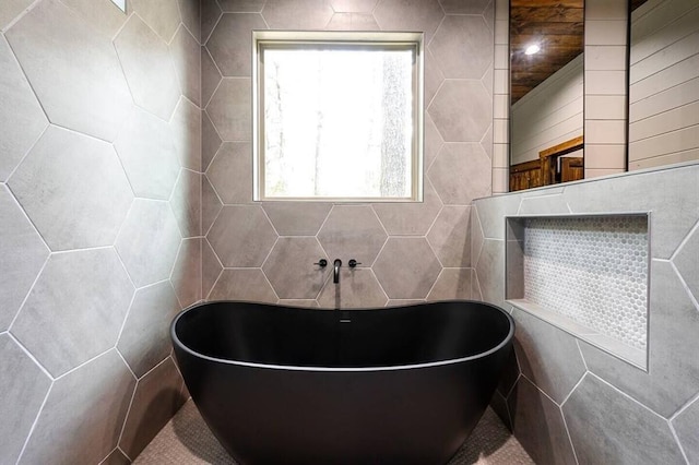 bathroom with tile walls and a bathtub