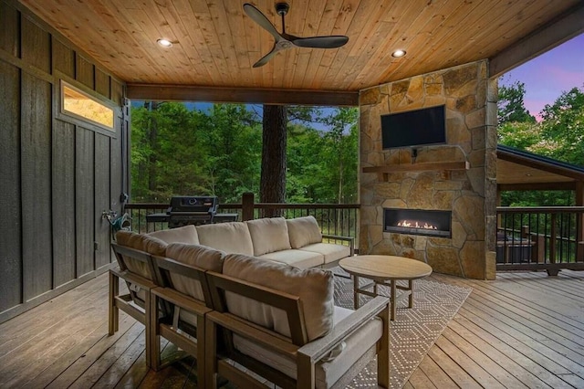 deck with ceiling fan, grilling area, and an outdoor living space with a fireplace