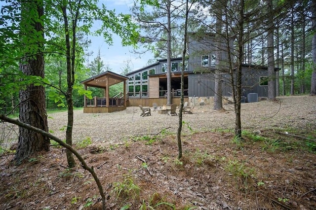 rear view of house featuring a wooden deck and central air condition unit