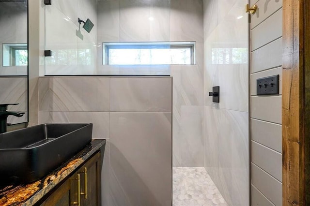 bathroom with vanity, tile walls, and walk in shower