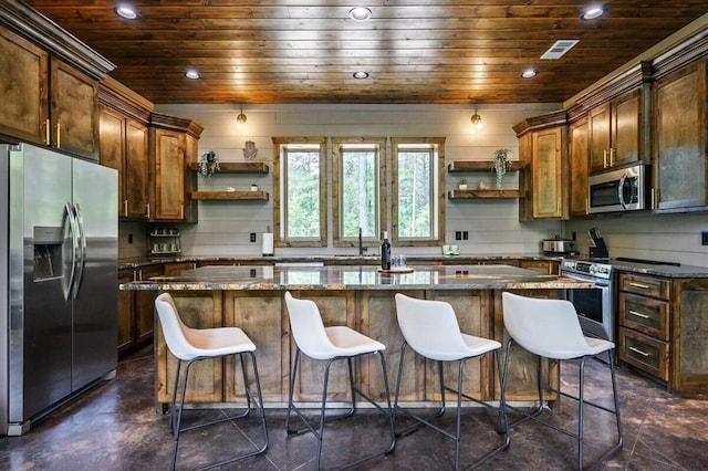 kitchen with dark stone countertops, appliances with stainless steel finishes, a breakfast bar, a center island, and wood ceiling