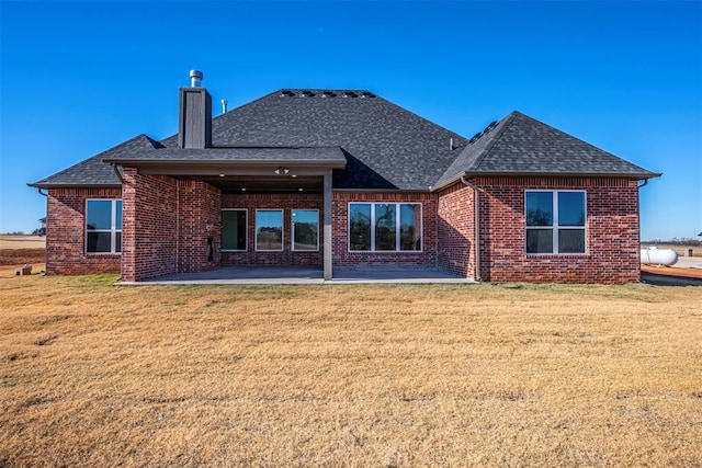 rear view of property featuring a yard and a patio